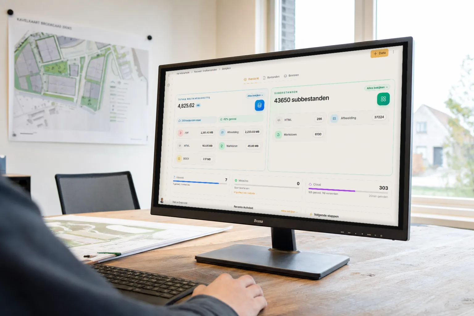 Projectontwikkelaar bekijkt op een monitor het Kennisbanken-dashboard van Vergunnex met bestandsomvang en vectorisatiestatus